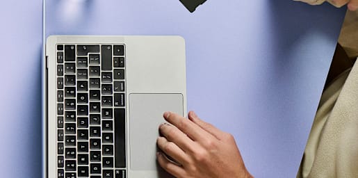 A woman with curly hair looking at her smartphone outdoors on a city street.