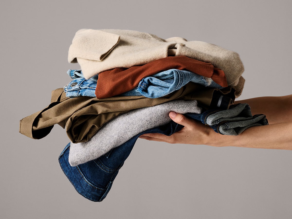 Person holding a pile of clothes