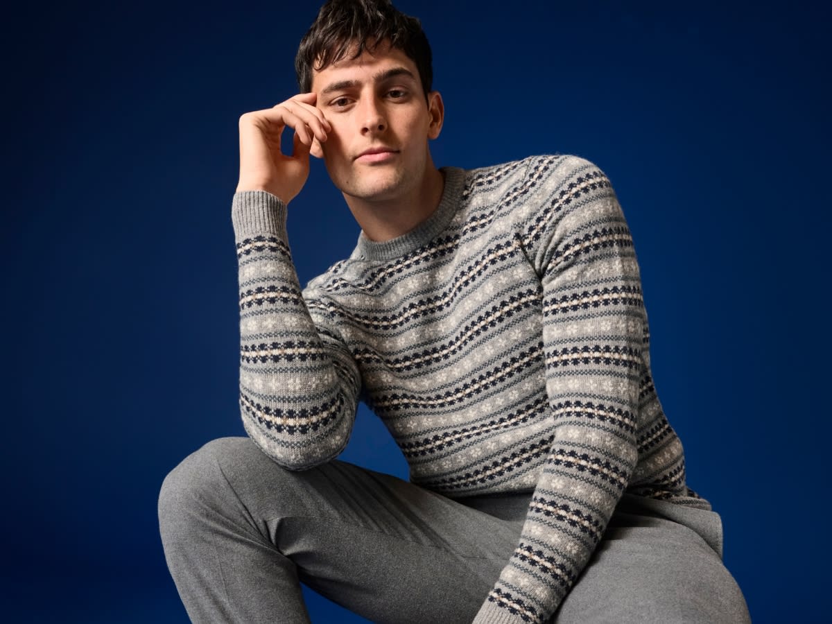 Man wearing grey patterned jumper. Shop 2 for £60 on lambswool jumpers
