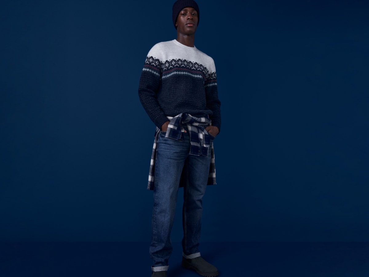Man wearing jeans and Fair Isle jumper. Shop 2 for £50 on selected denim