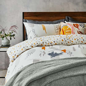 Patterned bedding on wooden double bed