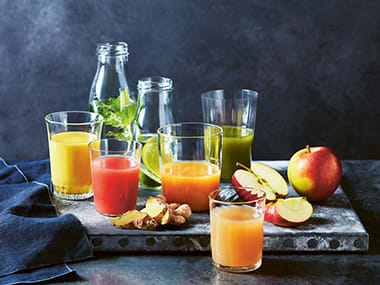 Table with several glasses of fruit juice on