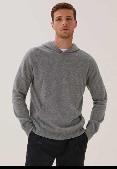 Man wearing grey marl M&S hoodie, white T-shirt and black trousers