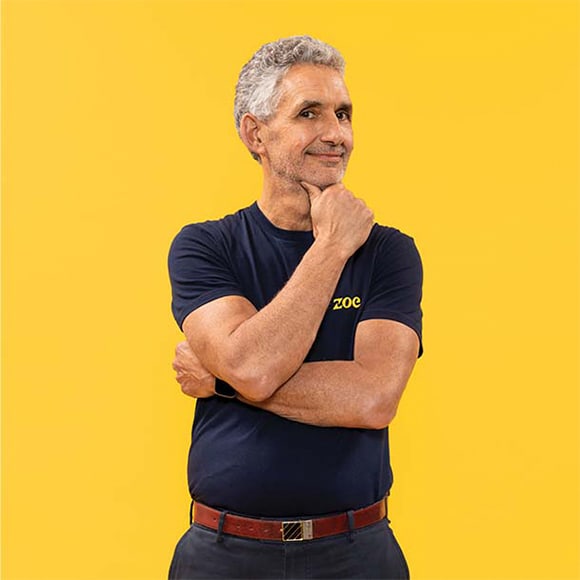Professor Tim Spector smiling on yellow background