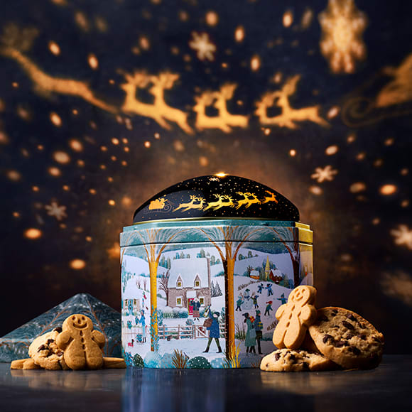 M&S snowy projection tin with lights in the background 