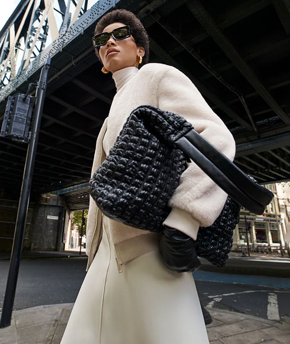 Woman wearing cream textured jacket and cream skirt. Shop women’s new-in