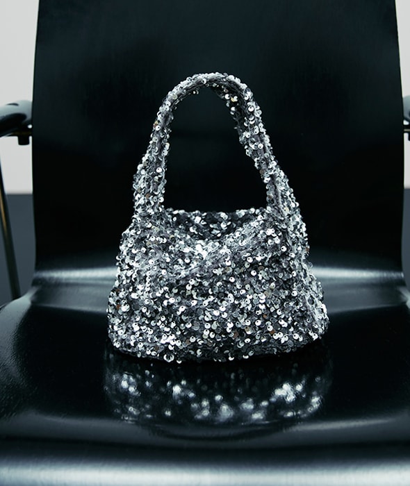 Silver sequin party bag on a black chair