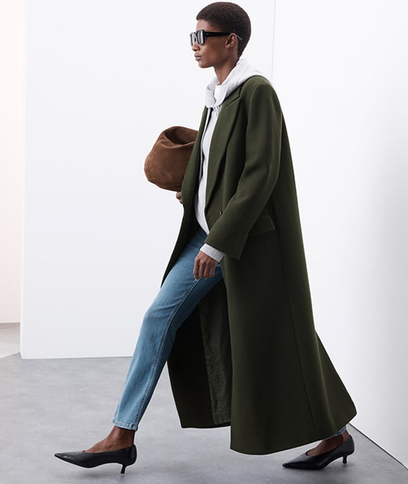 Woman wearing dark green tailored longline coat