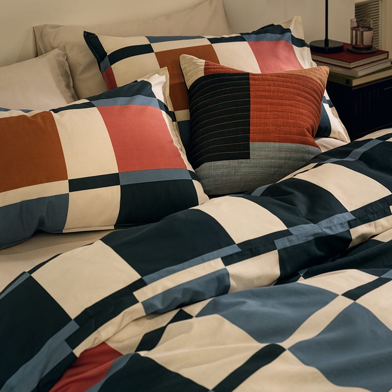 Bed with geometric bedding. Shop bedding