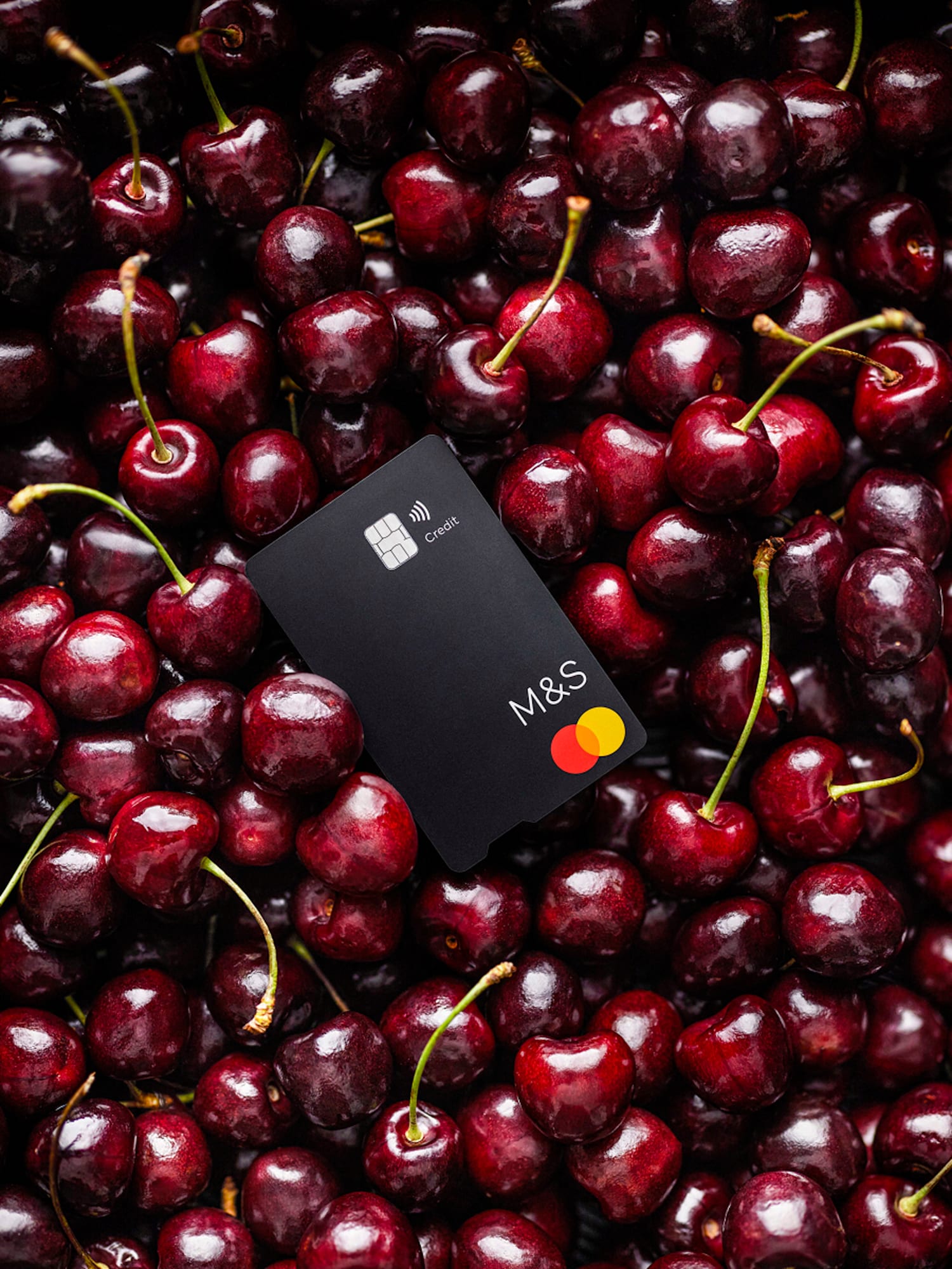 A credit card in a bowl of cherries