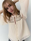 Blouse à manches bouffantes, encolure à nouer et empiècement à perles
