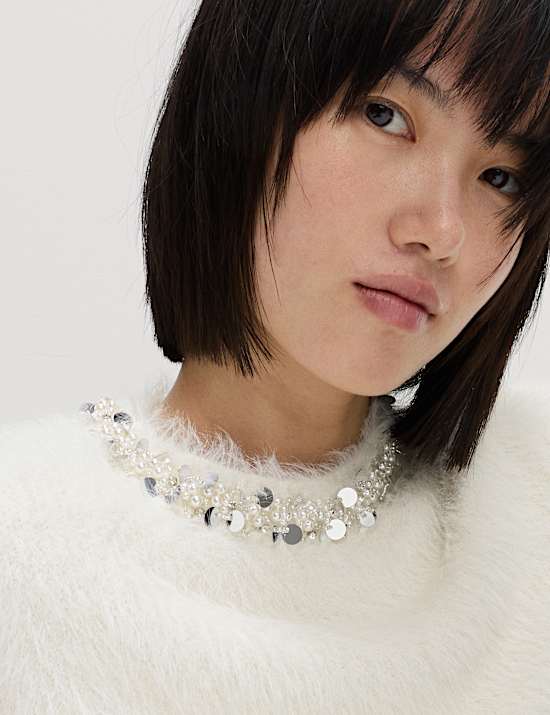 Πλεκτό εφαρμοστό τοπ με κλειστή στρογγυλή λαιμόκοψη και διακοσμητικές λεπτομέρειες