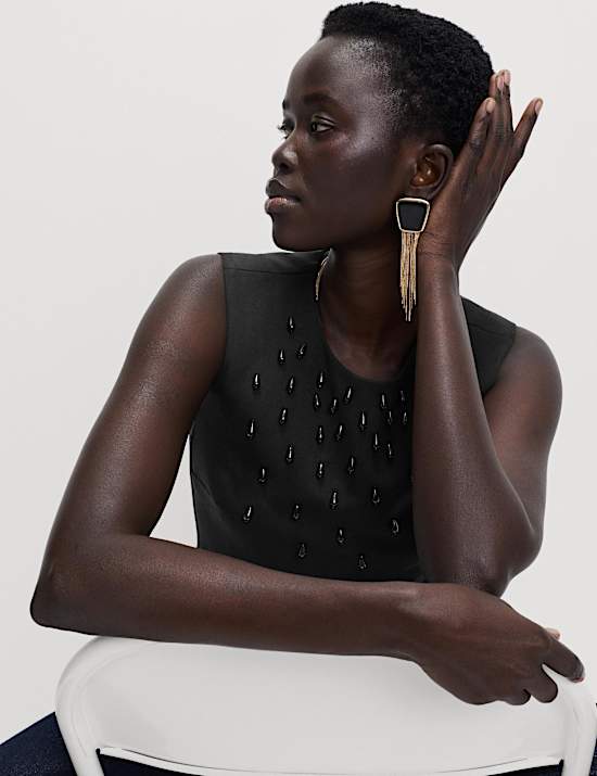 Eng anliegendes Oberteil mit Schößchen und Verzierung