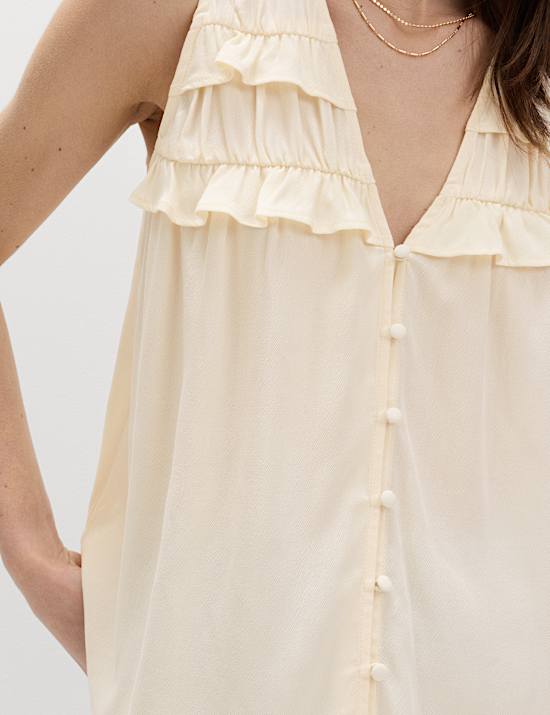 Top con cuello en pico de lyocell con detalle de volantes