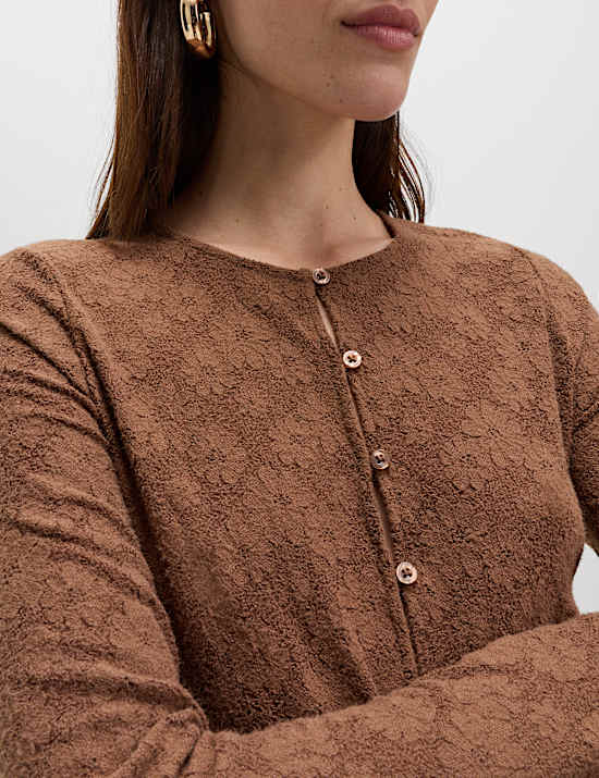 Comfortabele top met knoopsluiting en bloemdetail