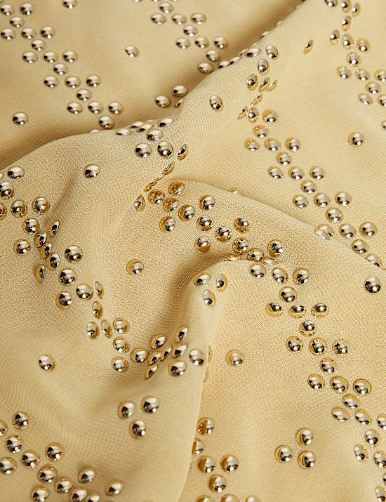 טופ בסגנון קומבינזון עם עיטורים, ניטים וצווארון עגול ורחב