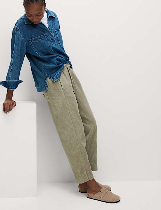 Παντελόνι χωρίς κούμπωμα με μπατζάκια που στενεύουν προς τα κάτω, κορδόνι που σφίγγει και ξεθωριασμένη όψη