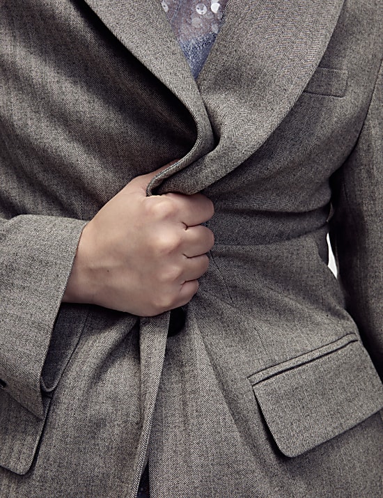 Ruimvallende blazer met één rij knopen en visgraatmotief