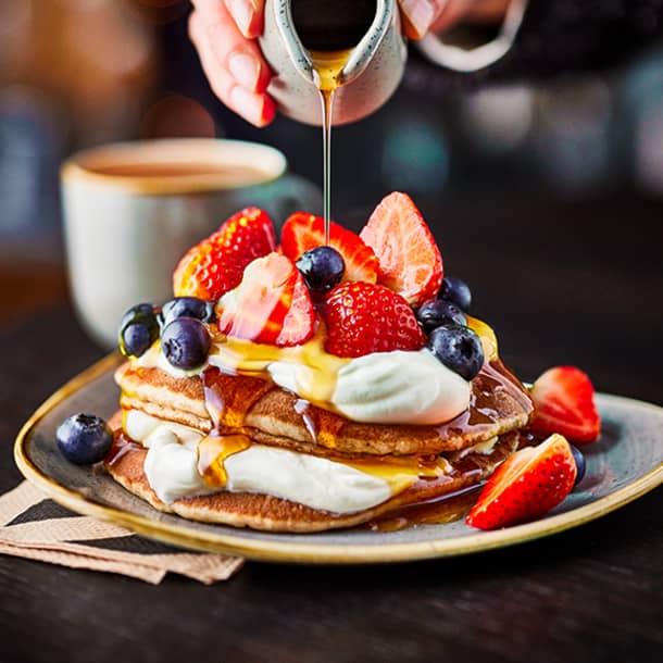 M&S pancake plate with hand pouring maple syrup on top